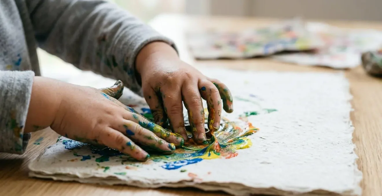Close-up of a child's hands engaged in creative art-making, emphasizing process over product in emotional regulation