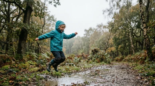 Young child wearing breathable waterproof jacket exploring outdoors in light rain, staying active and comfortable